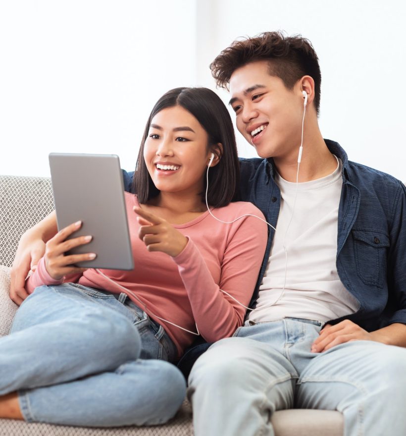 cheerful-asian-couple-using-digital-tablet-browsing-internet-at-home